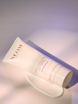 NEOM magnesium body butter on a soft grey background