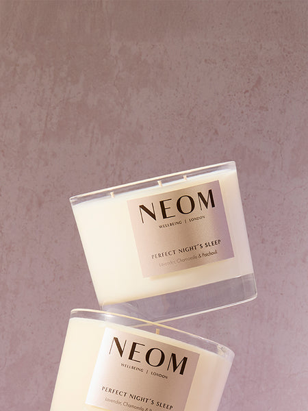 NEOM candle with a soft purple background