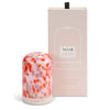 NEOM diffuser with red and pink design and matching packaging on a white background
