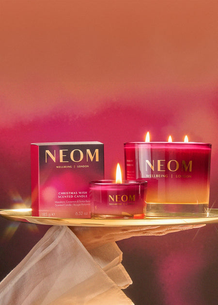 NEOM candles on a tray with a gradient background