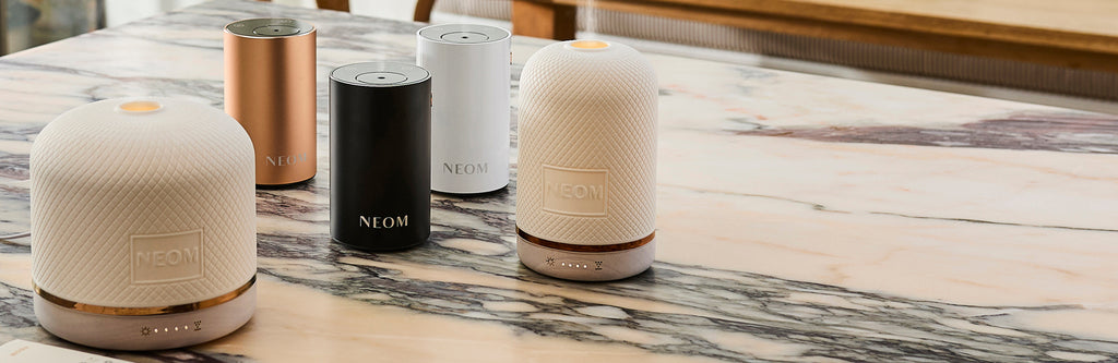 NEOM electric diffusers on a marble surface