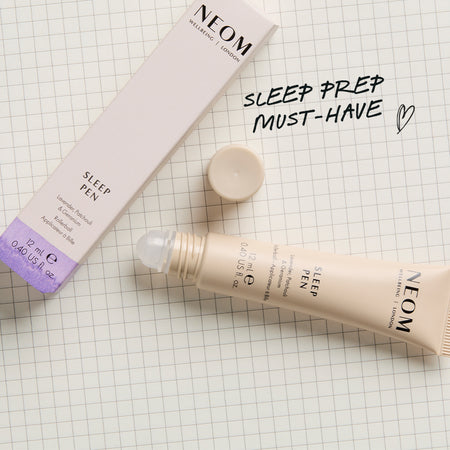 NEOM Sleep Pen on a checkered background with text saying 'Sleep Prep Must-Have'