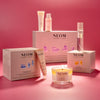 NEOM skincare products including bottles, boxes, and a candle on a pink background