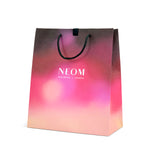 Gradient Christmas shopping bag with NEOM branding on a white background