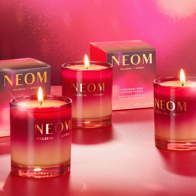 NEOM candles with a red gradient on a red background