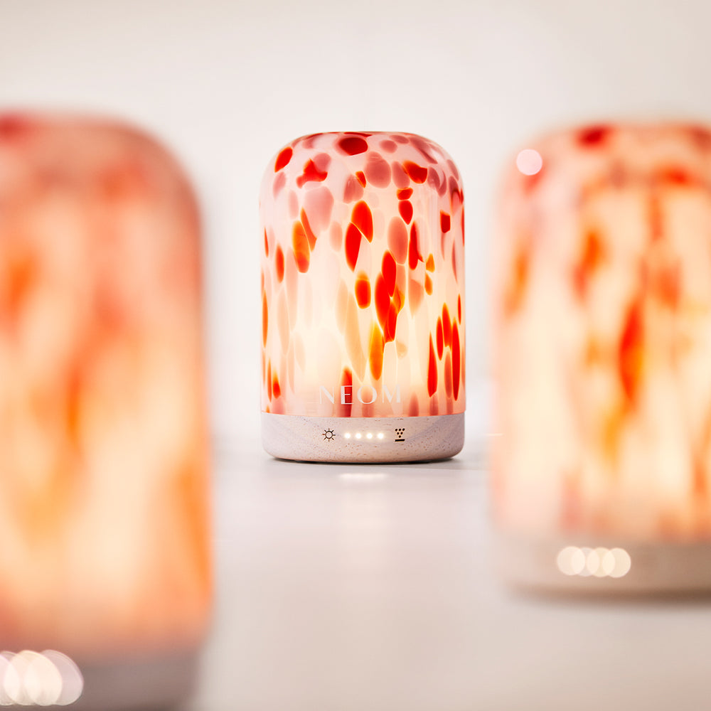 Three NEOM diffusers with a blurred background
