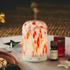 NEOM electric pod diffuser and essential oil on a table with decorative items
