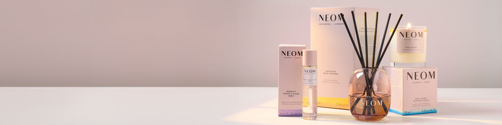 NEOM skincare products including a diffuser and bottles on a light background