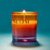 NEOM candle with a gradient colour on a blue background