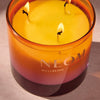 NEOM Cosy NIght's candle with three wicks on a neutral background