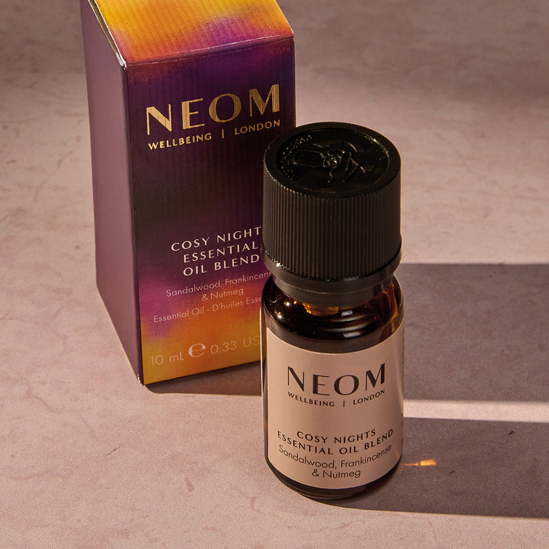 NEOM Cosy Night's essential oil blend and packaging on a neutral background