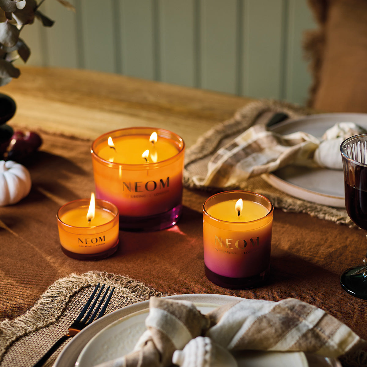 NEOM Cosy Night's candles on a table with a warm setting