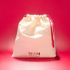 NEOM drawstring bag on a red background