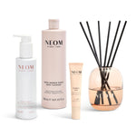 NEOM products including a bottle, tube, pen and diffuser on a white background