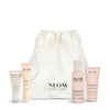 NEOM skincare products including a drawstring bag on a white background