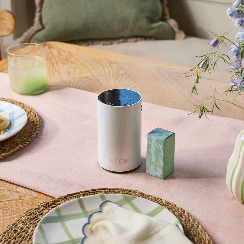 White NEON product on a pink surface with a green box and decorative elements.