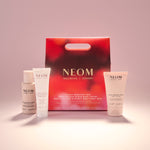 NEOM skincare products including a red box on a light pink background