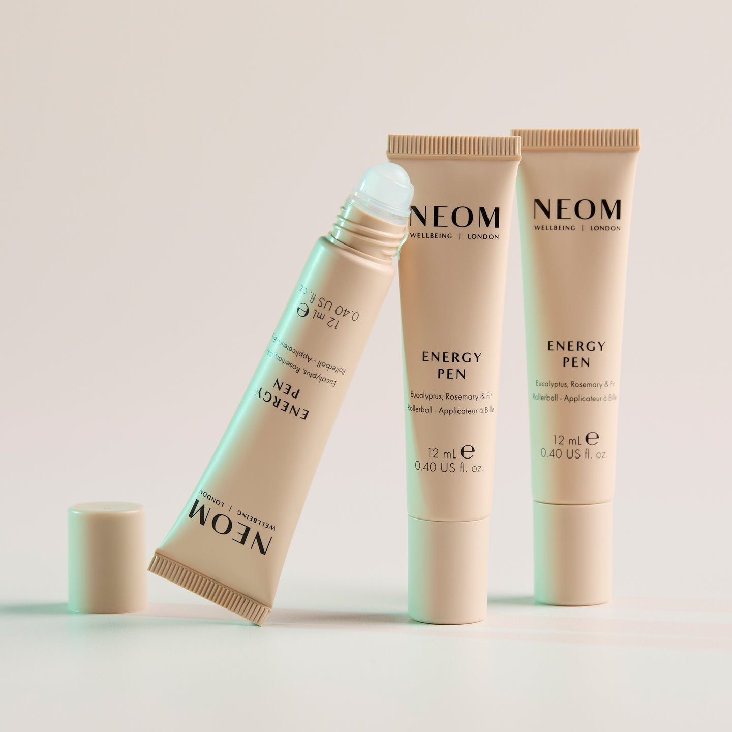 Three of NEOM Energy Pens on a light background