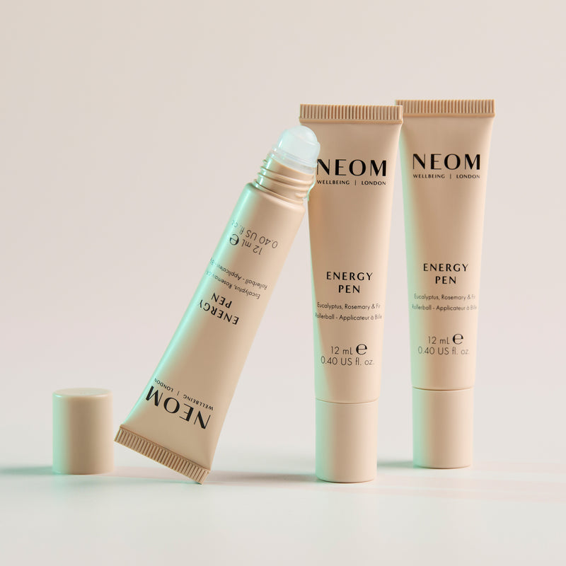 Three of NEOM Energy Pens on a light background