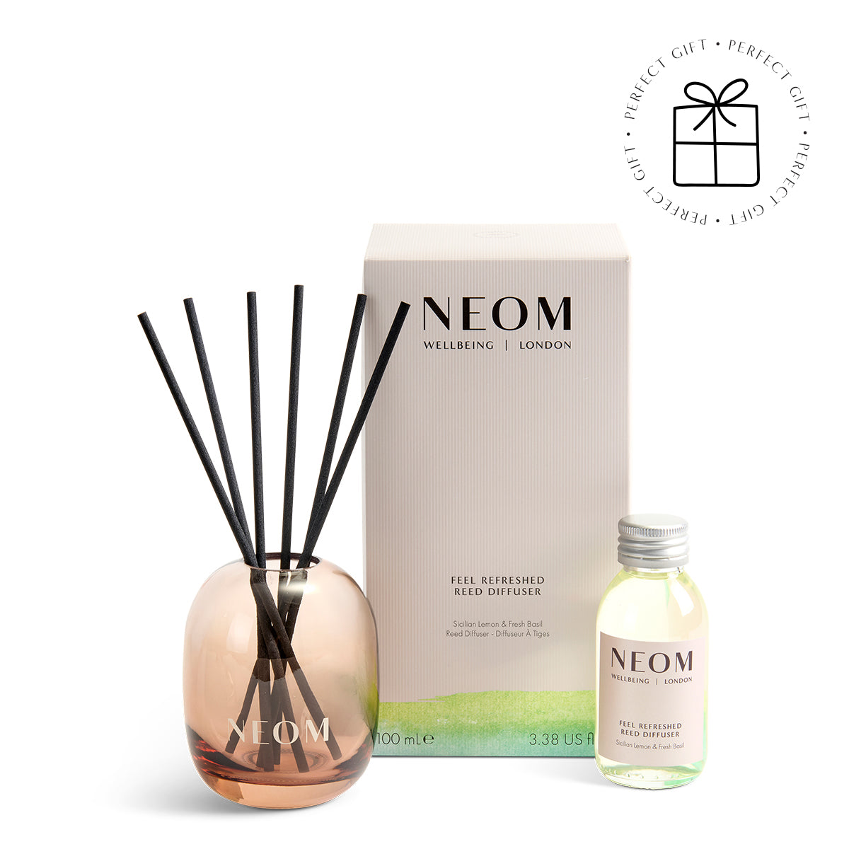 NEOM  diffuser set with rose gold diffuser, black reeds, and small bottle on a white background.