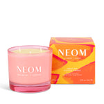 Pink NEOM candle with packaging on a white background