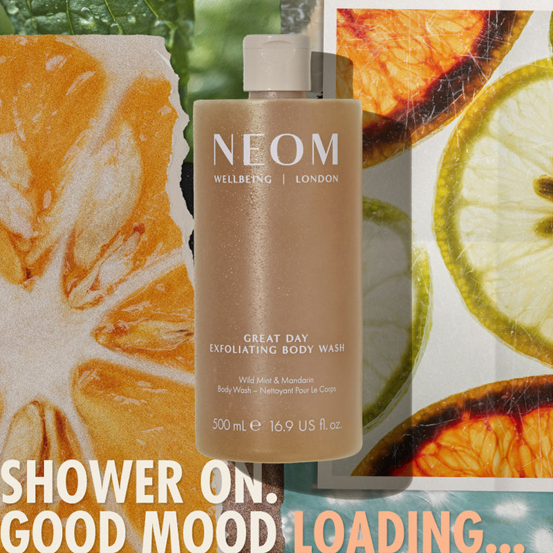 “NEOM Great Day Exfoliating Body Wash (500 ml) centered over a collage of citrus slices and greenery. Text reads: ‘Shower on. Good mood loading…’”