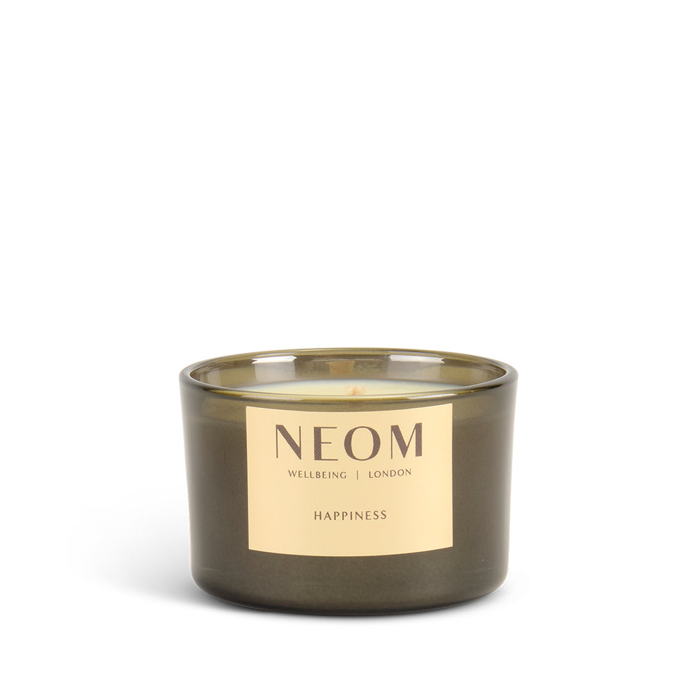 NEOM happiness travel candle with a gold label on a white background