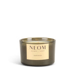 NEOM happiness travel candle with a gold label on a white background