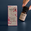 NEOM essential oil bottle and packaging on a dark background