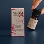 NEOM essential oil bottle and packaging on a dark background