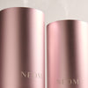 Two pink NEOM diffusers on a light gray background