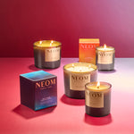 NEOM limited edition real luxury and happiness candles on a pink gradient background