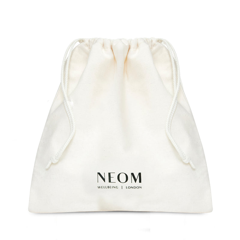 White drawstring bag with NEOM branding on a white background