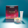 NEOM candle and body lotion with packaging on a blue background