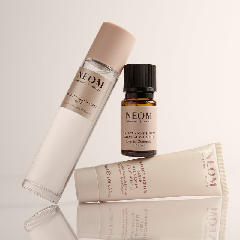 NEOM Perfect Night's Sleep Mist, Essential Oil and Magnesium Body Butter on a cream background