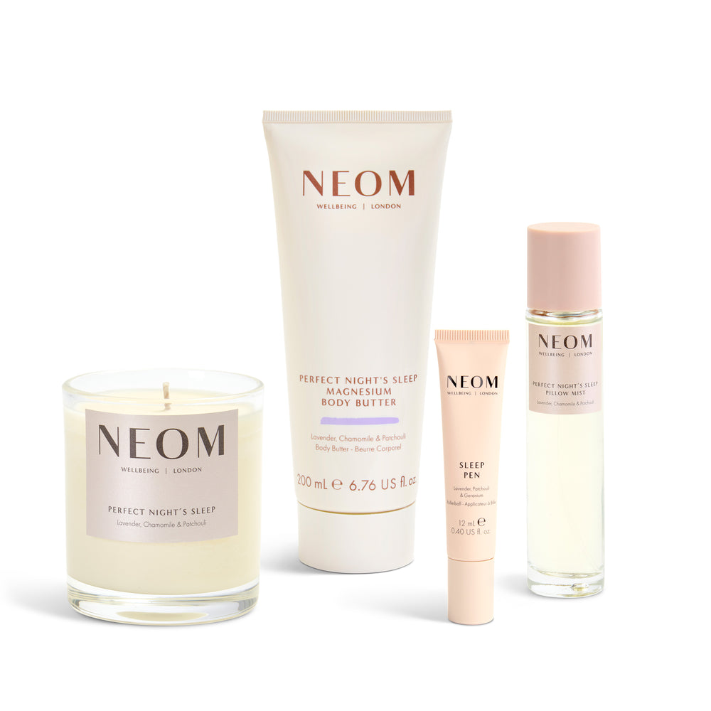 Neom skincare products including a candle, body butter, pen, and pillow mist on a white background