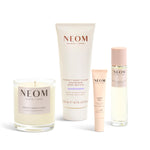 Neom skincare products including a candle, body butter, pen, and pillow mist on a white background