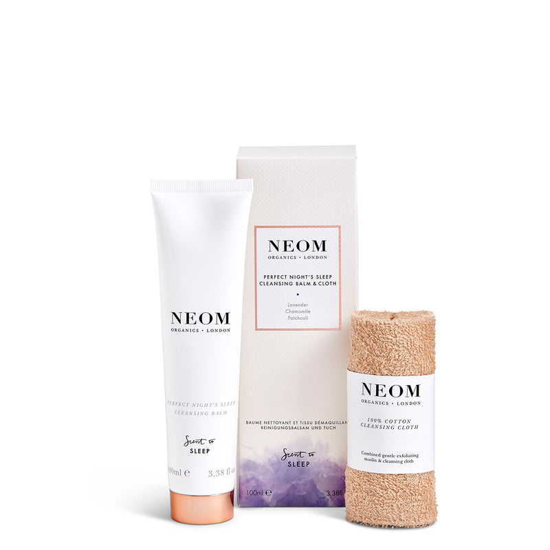 NEOM skincare products including a tube, cleansing balm, and cloth on a white background