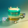 NEOM candle with a gradient design on a gradient background