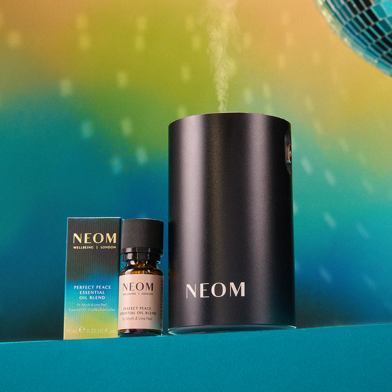 NEOM products including a diffuser, essential oil blend, and bottle on a gradient background