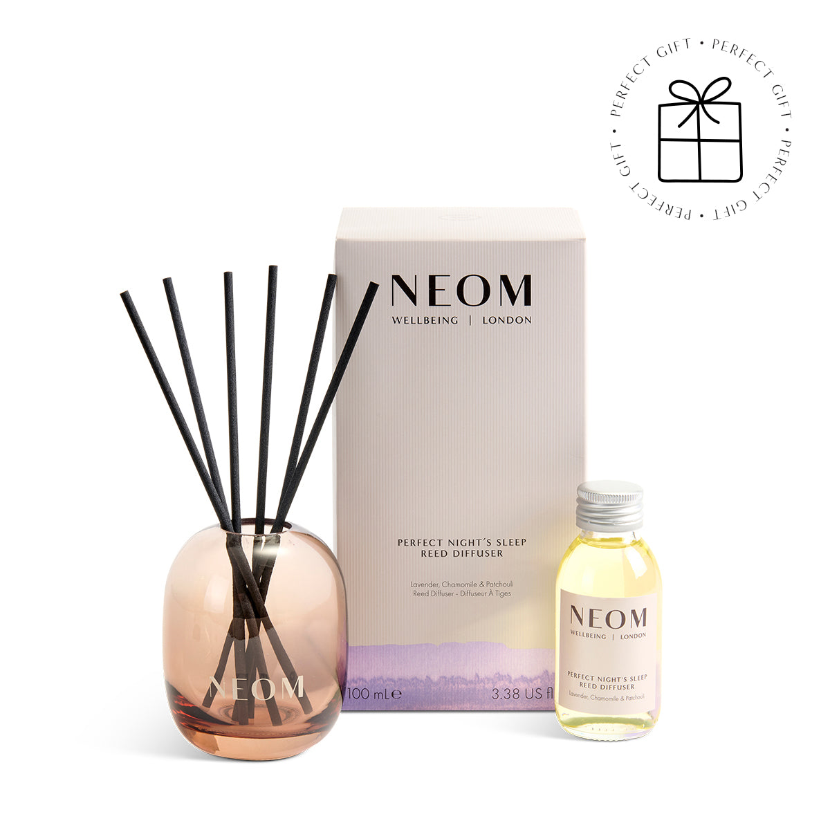 NEOM diffuser set with reeds and bottle on a white background with a Perfect Gift Roundel with a present