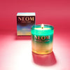 NEOM candle with a gradient effect on a red background