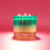 NEOM candle with a gradient design on a pink background