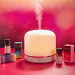 Neom diffuser and essential oils on a pink background