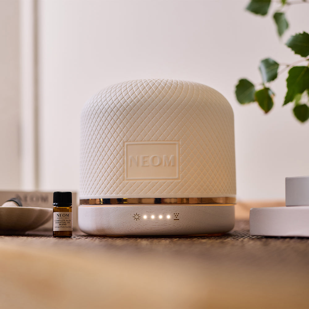 NEOM Wellbeing Pod Luxe aromatherapy diffuser styled with essential oils and home décor.