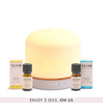 NEOM pod luxe diffuser with 2 essential oil blends with a banner saying '2 free oils, on us' on a white background