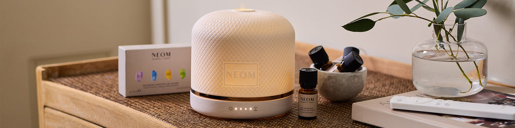 NEOM Wellbeing Pod Luxe aromatherapy diffuser styled with essential oils and home décor.