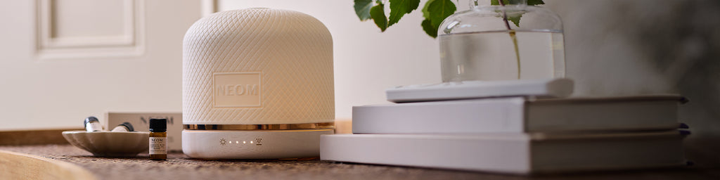 NEOM Wellbeing Pod Luxe aromatherapy diffuser styled with essential oils and home décor.