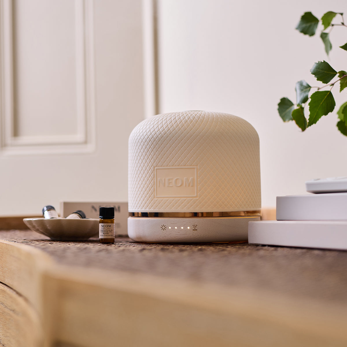 NEOM pod luxe with essential oil blends on a table
