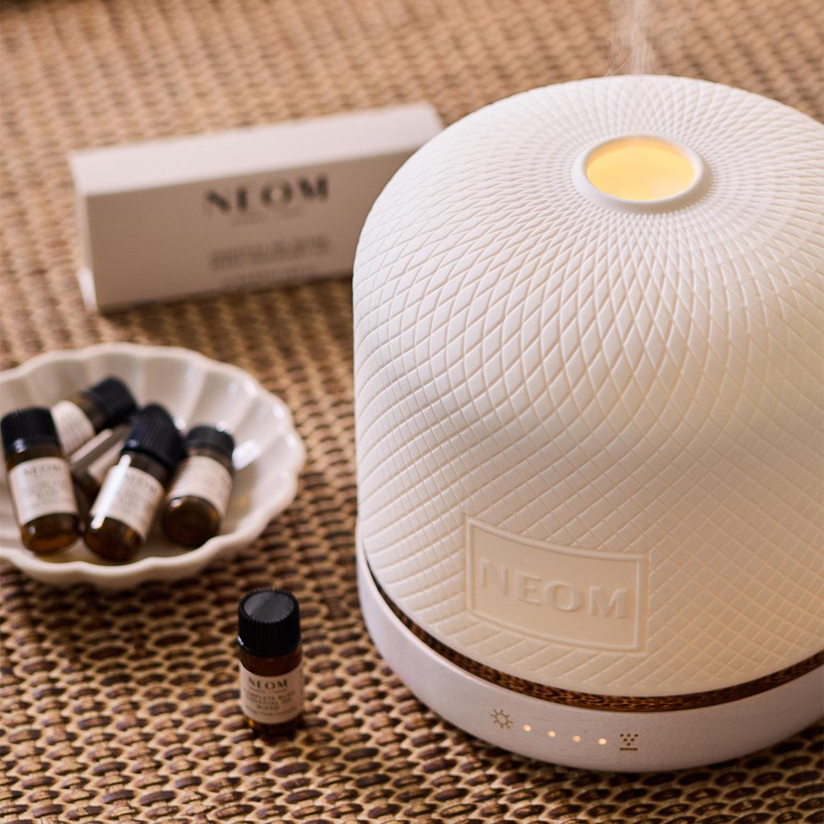 NEOM Pod Luxe with essential oils on a chest of drawers